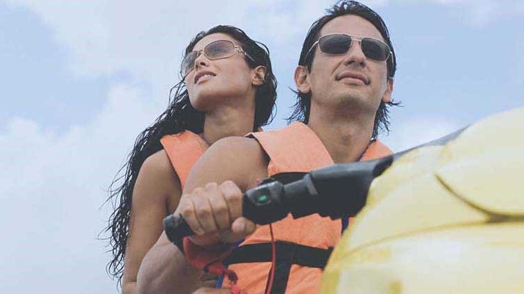 Couple riding a jet ski for the first time.