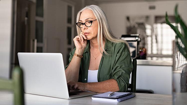 Woman sits in front of laptop, reviewing her 遗产规划.